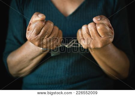 Close-up Old Hands Of Woman And Chain On Black Background, Concept No Freedom