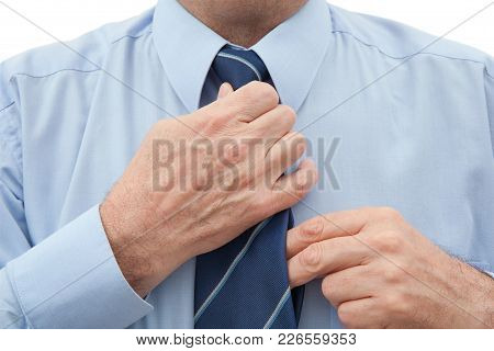 Businessman In A Blue Shirt Adjusting A Striped Blue Necktie On His Neck