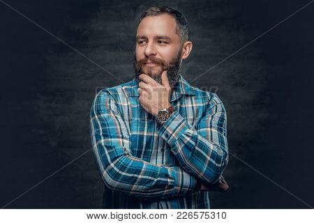 Portrait Of Serious Middle Age Bearded Male Dressed In Plaid Flannel Shirt Over Grey Background.