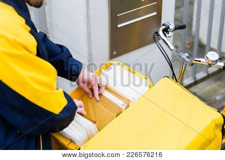 Postman delivering letters to recipient mailbox