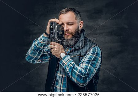 Portrait Of Bearded Middle Age Male Holds Vintage 8 Mm Video Camera Over Grey Background.