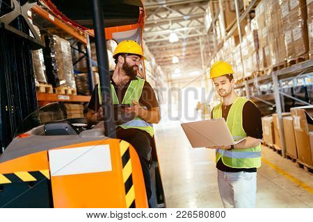 Warehouse Workers Working Together With Forklift Loader Trasnporter