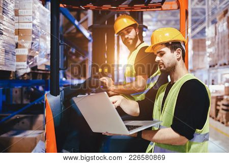 Warehouse Workers Working Together With Forklift Loader Trasnporter