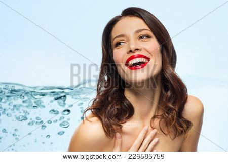 beauty, make up and people concept - happy laughing young woman with red lipstick over white background