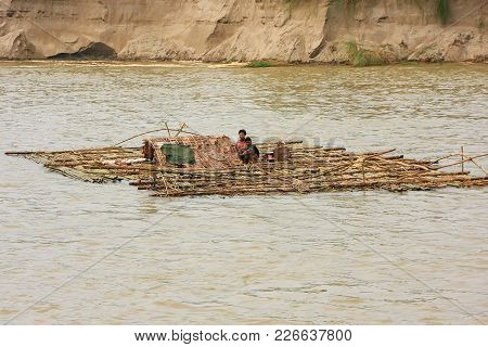 Mandalay, Myanmar - December 30: Unidentified Men Float On A Bamboo Raft Down Ayeyarwady River On De