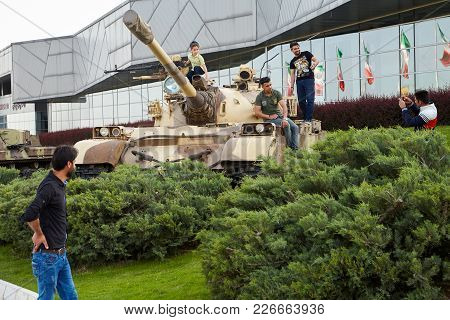 Tehran, Iran - April 28, 2017: Iranian Men And Boy Make Photos In Holy Defense Museum With Exhibits 