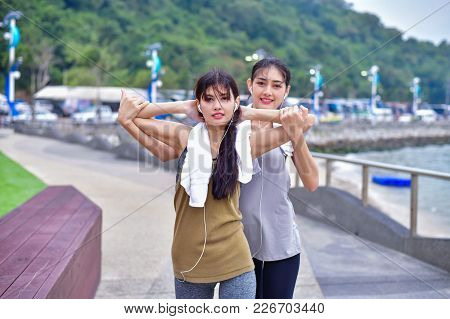Sports Concept. Beautiful Girl Is Exercising On The Beach With Warm Up. Beautiful Girl Is Happy To E