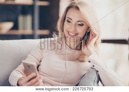 Close Up Portrait Of Attractive Pretty Woman  Siting On Couch In Living Room, Having, Using Earphone