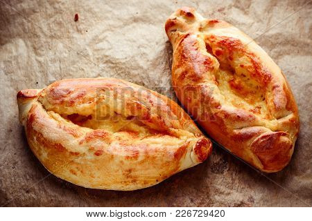 Two Homemade Ajarian Khachapuri On Wooden Table Close Up
