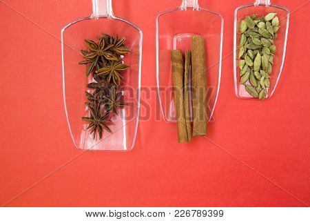 Glass Spoons With Dry Spices And Fresh Herbs On A Rose Background, Top View, Close Up