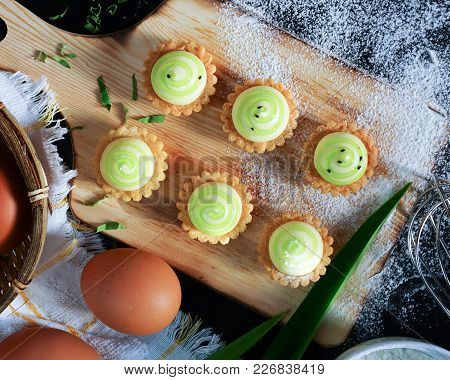 High angle view of egg tarts on the wooden board.