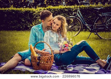 Lovely Couple On Picnik In A Park In Summer Sunny Day.