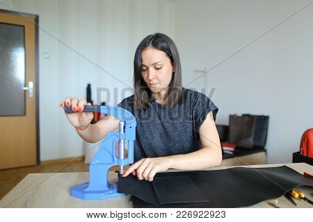 Female Fixing Snap On Leather Pattern Using Special Mechanism. Young Designer Decided To Try To Make