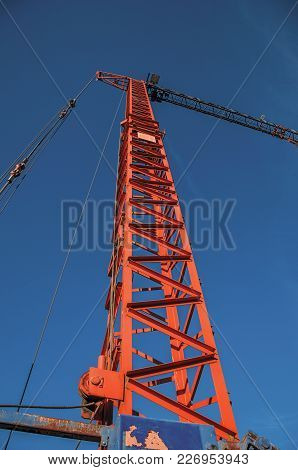Close-up Of Crane In A Construction Area At Sunset And Blue Sky In Tielt. Charming And Quiet Village
