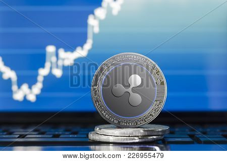 Physical Ripple (xrp) Cryptocurrency; Silver Ripple Coin On The Background Of The Chart