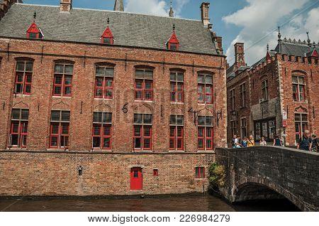 Bruges, Belgium - July 05, 2017. People On Bridge And Old Buildings At Canal In Bruges. With Many Ca