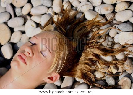 Junge Frau auf einem Kiesstrand liegen
