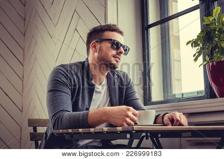 Casual Bearded Man In Eyeglasses Drinking Morning Coffee.