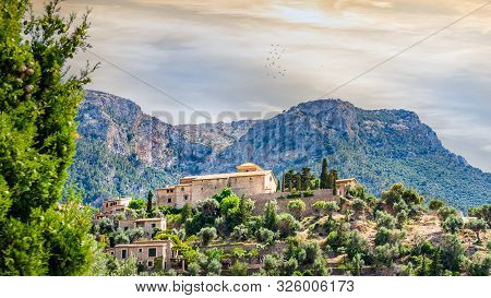 Beautiful Old Town Of Deia With Church Of Saint Joan Baptista On Terraced Hill With High Mountains A
