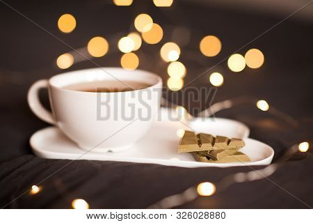 Cup Of Green Tea With Matcha Chocolate And Floers On Tray Over Lights. Good Morning. Breakfast.