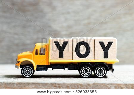Truck Hold Letter Block In Word Yoy (abbreviation Of Year Over Year) On Wood Background