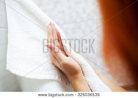 Hygiene And Hand Care. Woman Using Towel For Wiping Hands Dry After Washing In Light Bathroom At Hom