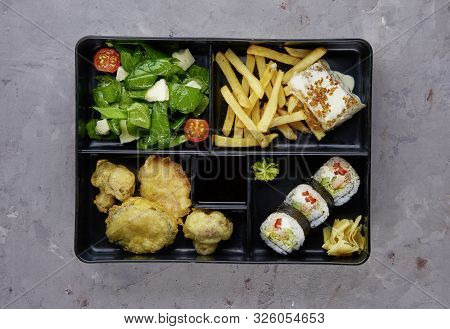 Fod Portion In Japanese Bento Box With Sushi Rolls And Salad