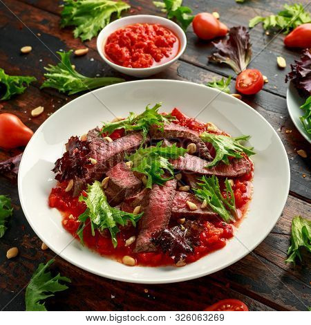 Beef Steak With Romesco Sauce, Nuts And Vegetables On White Plate