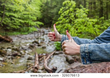 Fimale Traveler Showing Thumb Up Against The Backdrop Of Nature. Tourism Concept. Copyspace. Mountai
