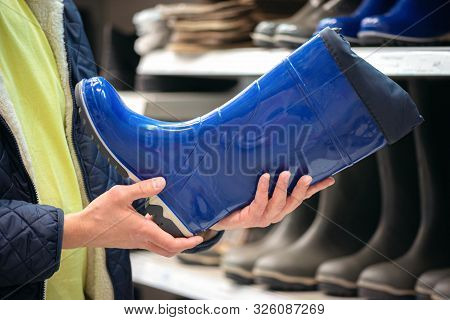 Gardener Buying A New Rubber Boots In A Store.