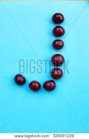 Letter J Fresh Cherry Alphabet Blue Color Flat Lay