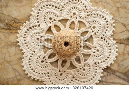 Threads, Crocheted Round Napkin. White Napkin Like A Flower. On A Marble Light Background. Balls Of 
