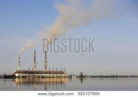 Thermal Power Station Tall Pipes With Thick Smoke Reflected In Lke Water Surface. Pollution Of Envir