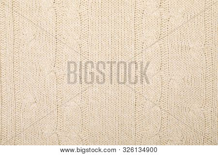 Real beige melange knitted fabric with cable pattern textured background
