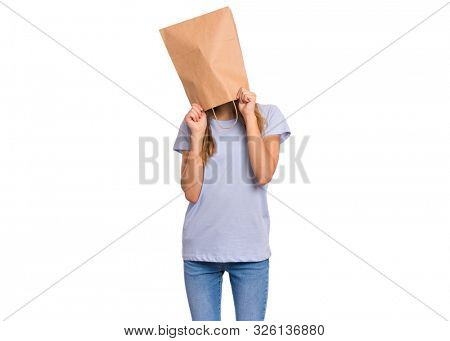 Portrait of teen girl with paper bag over head. Teenager cover head with bag holding hand near face isolated on white background. Child pulling paper bag over head.