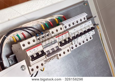 A Series Of Modular Circuit Breakers In An Electrical Cabinet With Electrical Wires Or Cables Connec