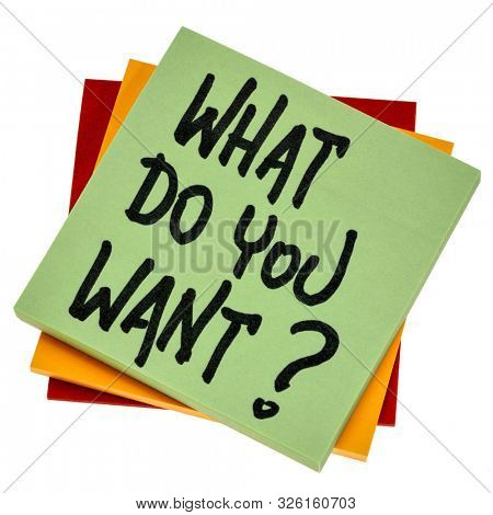 What do you want? Handwriting on an isoalted note. Personal development, aspiration and career concept.