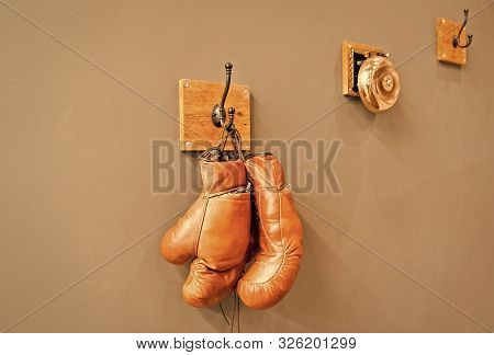 For All Your Boxing Needs. Pair Of Retro Sparring Boxing Gloves Hooked On Wall. Old Protective Sport