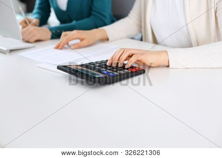 Accountant Checking Financial Statement Or Counting By Calculator Income For Tax Form, Hands Close-u