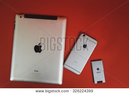 Moscow, Russia - April 25 2019: Ipod, Iphone And Ipad Lying In A Row . Production On Red Background.