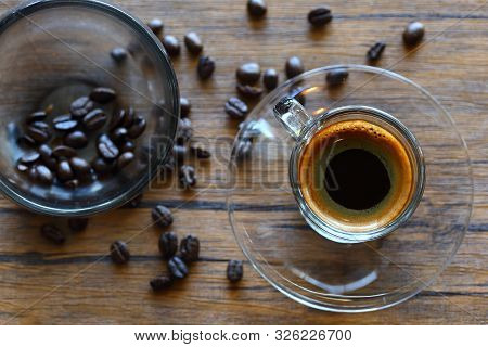 Hot Of Black Coffee And Coffeebeans On Woodden Background.