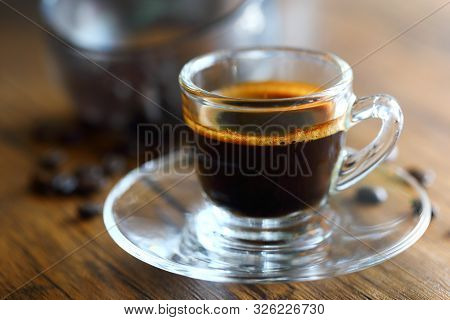 Black Coffee And Coffeebeans On Woodden Background.