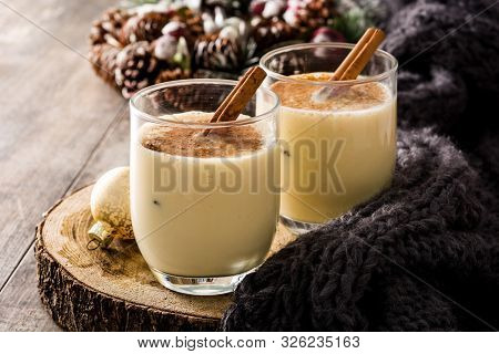 Homemade Eggnog With Cinnamon In Glass On Wooden Table. Typical Christmas Dessert.