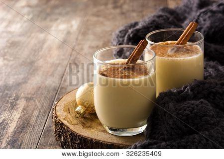 Homemade Eggnog With Cinnamon In Glass On Wooden Table. Typical Christmas Dessert. Copy Space