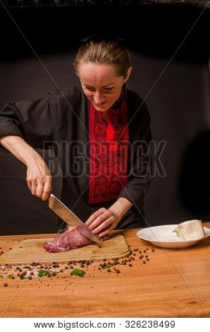 Female Hands With A Knife In Their Hand Cut Fresh Meat On A Table