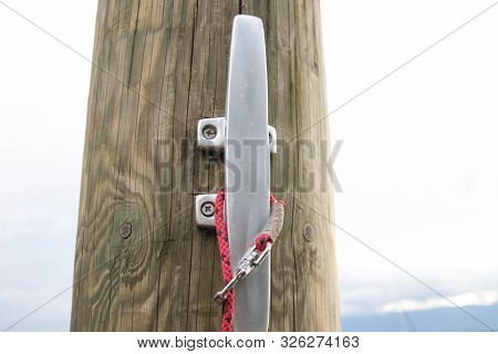 Close Up To A Metalic Boat Cleat On  Wood Dock Pier