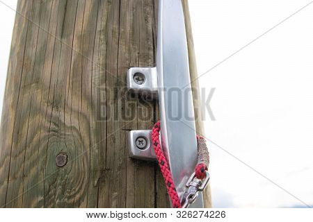 Close Up To A Metalic Boat Cleat On  Wood Dock Pier