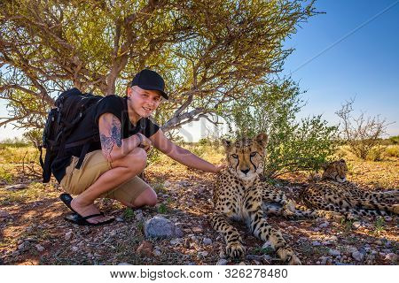 Mariental, Namibia - March 25, 2019 - Tourist Plays With Two Cheetahs