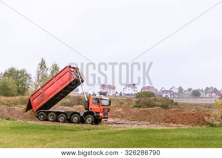 A Large 70-ton Dump Truck Brought Sand To A New Construction Site To Add Land