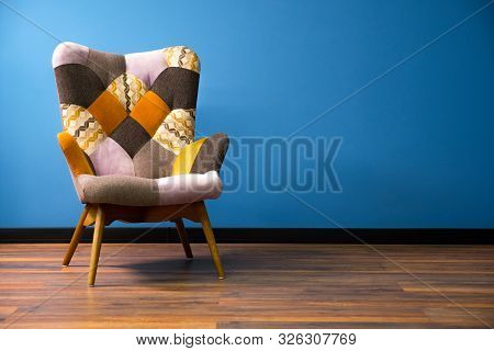 Empty Modern Chair On Wooden Floor. Solid Wall With Contrast Baseboard Background. One Object Of Int
